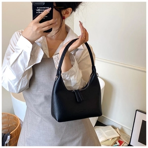 Detail of black lychee grain leather hobo bag featuring silver zipper and long pullers