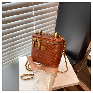 Détail du mini sac à chaîne motif crocodile avec ornement floral camélia doré