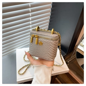 Détail du mini sac boîte gris motif croco avec fermoir fleur dorée et chaîne