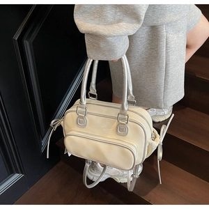 Detail of Boston-style handbag with metallic silver trim and drawstring side bows