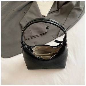 Detail view of black pebble leather bag with silver zipper and beige woven inner pockets
