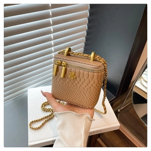 Détail du mini sac kaki motif crocodile avec rivet camélia doré et bandoulière chaîne