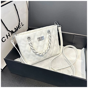 Détail du sac cabas matelassé blanc avec poignée chaîne argentée et plaque métallique