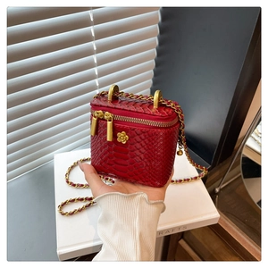 Détail du mini sac boîte rouge motif crocodile avec breloque camélia dorée et chaîne