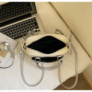 Top view of cream and silver handbag interior capacity with dual zippers and long strap