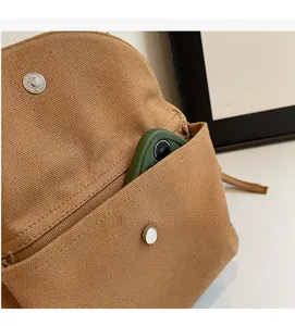 Detail of canvas bag with practical front pocket holding a green smartphone