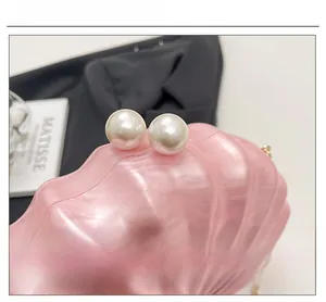 Sac de soirée coquillage rose avec surface irisée et deux grands fermoirs en perles
