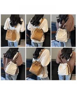 Detail view of canvas drawstring bucket bags in brown and beige with adjustable straps