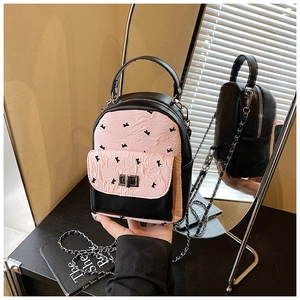 Detail of mini quilted backpack in black and pink with bow accents and silver twist lock