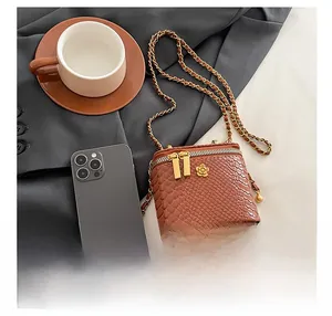 Détail de la texture crocodile marron et du zip en fleur dorée du mini sac