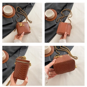 Détail d'un sac boîte marron effet croco avec zips fleurs dorées et bandoulière chaîne