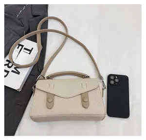 Detail view of beige woven crossbody bag with brown leather trim and smartphone size scale