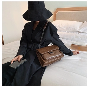 Sac à bandoulière matelassé marron avec coutures en V et fermoir rotatif en métal