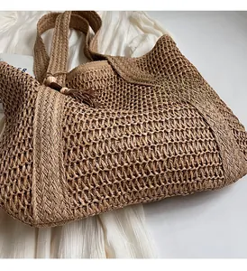 Macro view of woven straw tote bag with wood beads and fringe tassel decorations