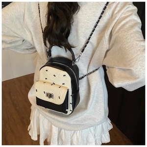 Detailed view of fashion mini backpack showing contrast color print and metal chain strap