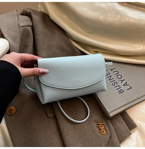 Close-up of light blue litchi texture PU leather crossbody bag with flap and slim strap