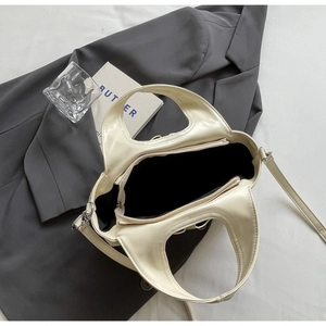 Top view detail of creamy white handbag showing spacious zipper compartment and inner lining
