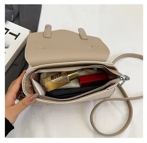 Interior view of beige leather crossbody bag showing spacious compartments for essentials