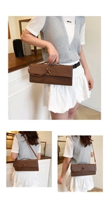 Detail of dark brown woven baguette bag with embossed leather texture and metal buckle