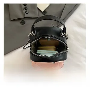 Internal storage view of mini quilted chain bag showing phone and makeup accessories