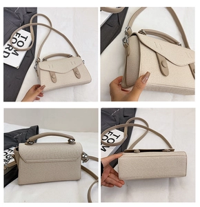 Detail view of beige canvas tote bag with flap buckle and adjustable strap
