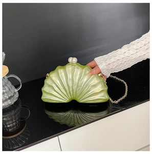 Détail du sac de soirée en acrylique marbré en forme de coquille avec fermoir perle