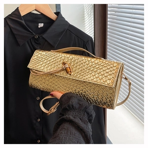 Detailed close-up of woven metallic gold bag with unique bamboo wood lock and texture
