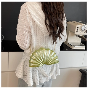 Détail du sac bandoulière vert clair en forme de coquillage avec fermoir perle et chaîne