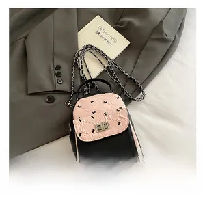 Detail of pink and black quilted backpack with silver rotary lock and chain strap