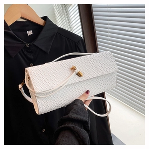 Close-up of white crocodile texture baguette bag with an elegant golden twist buckle