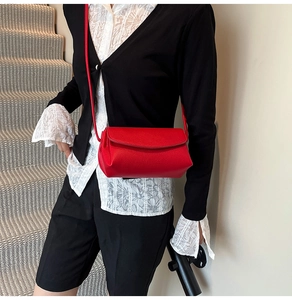 Close-up of red lychee pattern leather shoulder bag with fine stitching details