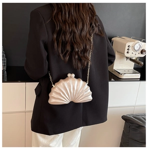 Détail du sac de soirée en forme de coquille avec fermoir perle et chaîne dorée