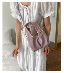 Detail view of pink nylon bucket bag with metallic accents and stylish shoulder strap