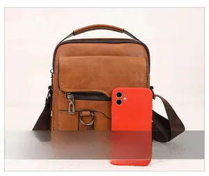 Brown leather crossbody bag detail with multi-pocket design and size comparison to phone