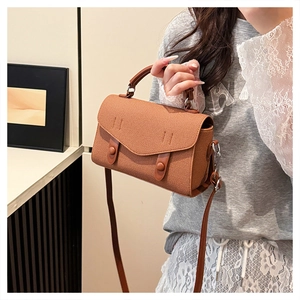 Detailed shot of a brown vintage tote bag featuring a flap closure and round buckle accents