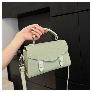Detail of mint green handbag featuring fine diagonal texture and stylish envelope flap