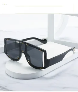 Close-up of oversized black sunglasses featuring delicate gold rivet studs on the frame