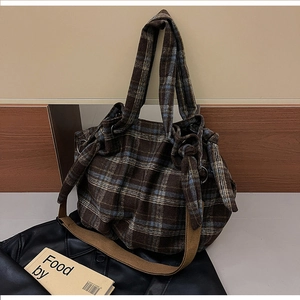 Detail of vintage brown and blue plaid tote bag with wide shoulder strap and side knot
