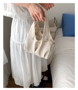 Chic cream tote bag with double pockets and metallic D-ring detail on soft canvas fabric