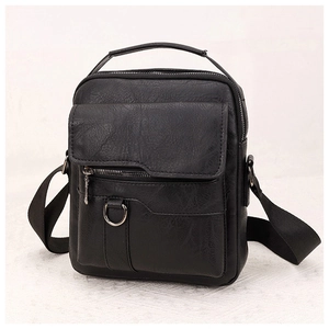 Detail of black pebbled PU leather texture and flap pocket on a casual shoulder bag