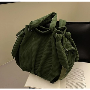 Detail of dark green corduroy tote bag featuring side knot design and metal ring buckle