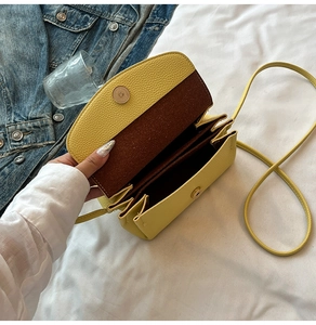 Detail view of yellow crossbody bag showing internal compartments and textured leather