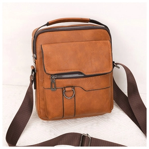 Close-up of textured tan PU leather shoulder bag featuring metal zippers and buckle details