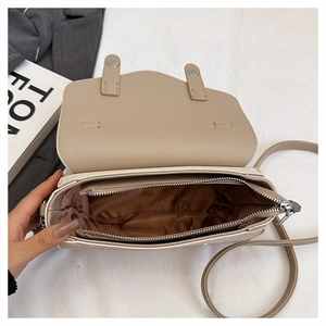 Top-down view of open beige leather bag showing brown satin lining and zipper pocket