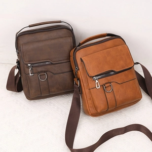 Close-up of brown faux leather messenger bag showing zipper details and silver D-ring hardware