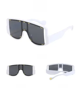 Detailed view of white oversized square sunglasses with gold rivet studs and dark grey lenses