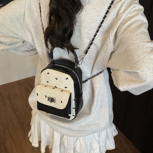 Mini black and white quilted leather backpack with silver chains shown on model back