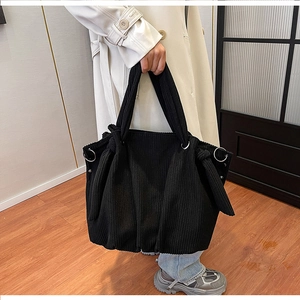 Detail of black corduroy hobo bag with large capacity and silver ring metal accents