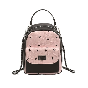 Quilted mini backpack with pink bow pattern and metallic chain strap in front view