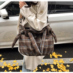 On-body shot of a large plaid corduroy hobo bag featuring autumn-style checkered pattern